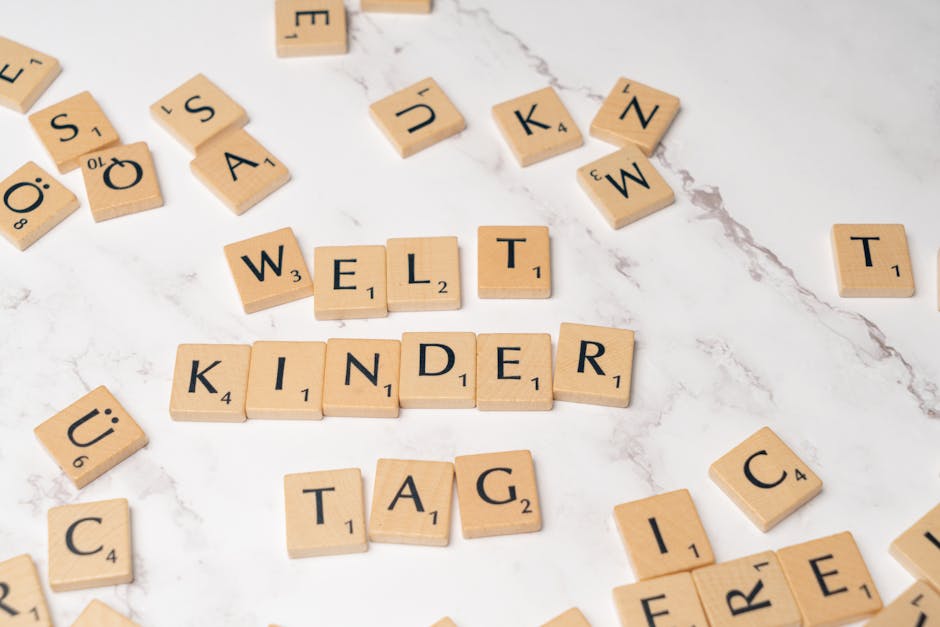 Scrabble tiles forming the words 'Welt Kinder Tag' on a marble background, symbolizing children's day.